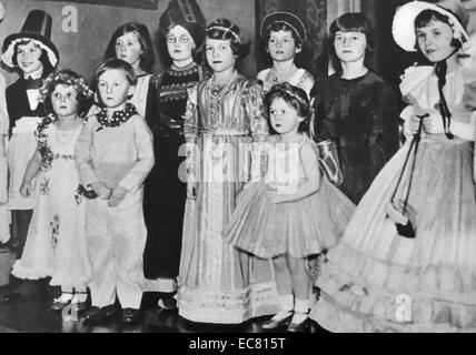 Die Prinzessinnen an einer Partei. Sie sind zu einem fancy dress Tanz, der von Viscountess Astor gezeigt, am St. James's Square. Prinzessin Elizabeth gekleidet in einem Tudor Kleid, die Hand der Prinzessin Margaret. Stockfoto