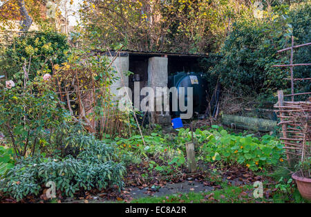 ÖLTANK IM VERWILDERTEN HERBST GARTEN VOR ORDENTLICH FÜR DEN WINTER Stockfoto