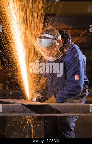 Ein Handwerker tragen persönlicher Schutzausrüstungen bei der Arbeit mit Stahl und Handwerkzeugen in einem industriellen Workshop im Vereinigten Königreich Stockfoto