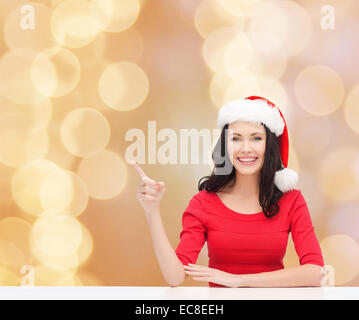 lächelnde Frau in Helfer Weihnachtsmütze Stockfoto