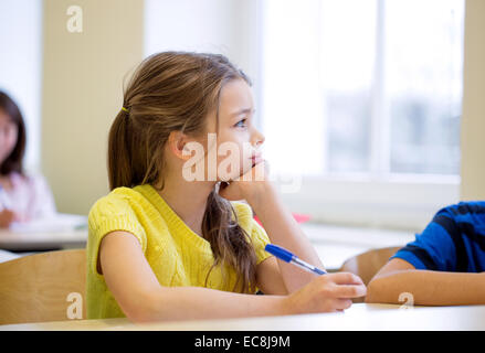 Schulmädchen mit Stift Langeweile im Klassenzimmer Stockfoto