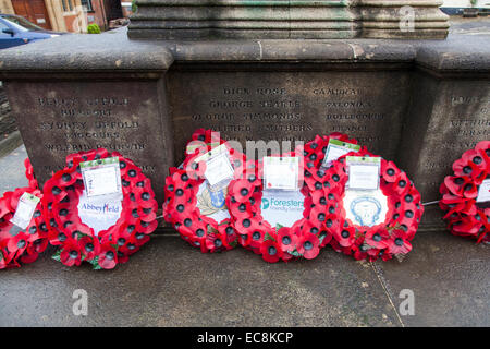 Mohn Kränze niedergelegt gegen die Basis der ein Kriegerdenkmal. Stockfoto