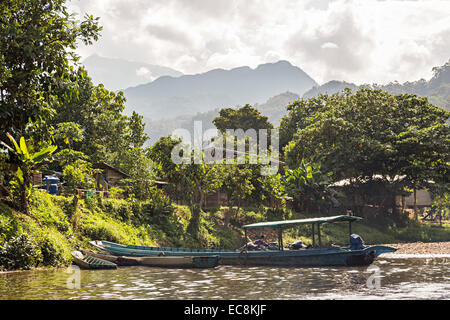 Boot und Dorf am Fluss Melinau, Mulu, Malaysia Stockfoto