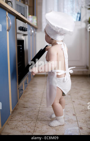 Baby-Chef kocht im Ofen Essen Stockfoto