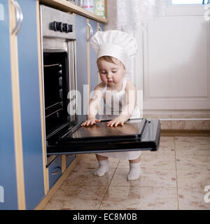 Baby-Chef kocht im Ofen Essen Stockfoto