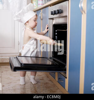 Baby-Chef kocht im Ofen Essen Stockfoto