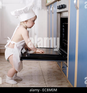 Baby-Chef kocht im Ofen Essen Stockfoto