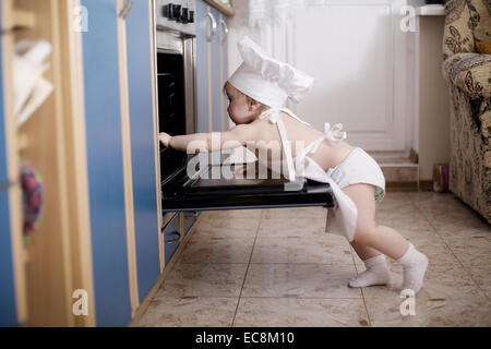 Baby-Chef kocht im Ofen Essen Stockfoto