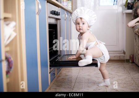 Baby-Chef kocht im Ofen Essen Stockfoto