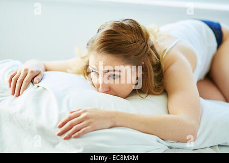 Aufgeregt Mädchen auf Bett liegend Stockfoto