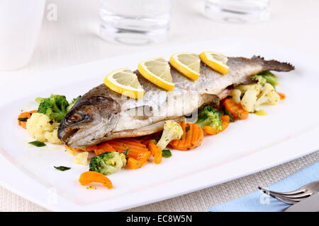 Gegrillte ganze Forelle mit Gemüse und Zitrone, horizontale Stockfoto