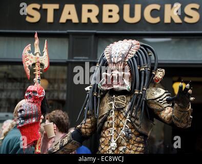 Darsteller in Alien Predator Kostüm außerhalb Starbucks in Edinburgh Stockfoto