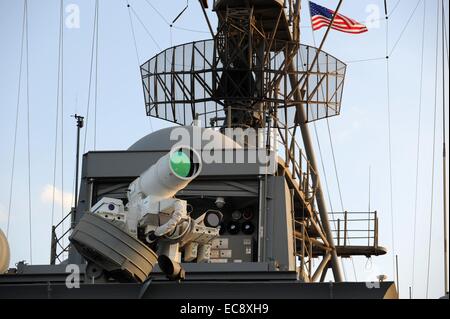 Ein US-Marine Austin-Klasse amphibischen Dock Transportschiff USS Ponce führt eine operative Demonstration mit dem Büro des Naval Research Laser Waffensystem 15. November 2014 in den Persischen Golf. 30 Kilowatt Laser-Waffensystem wurde an Bord der USS Ponce diesen Sommer als Teil eines $ 40 Millionen-Programm installiert und hat von der Marine am 10. Dezember 2014 betriebsbereit erklärt worden. Stockfoto