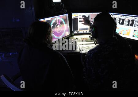 US Navy Matrosen betreiben die neu eingesetzten Gesetze, Laser-Waffe-System an Bord der Austin-Klasse amphibischen Dock Transportschiff USS Ponce 16. November 2014 in den Persischen Golf. 30 Kilowatt Laser-Waffensystem wurde an Bord der USS Ponce diesen Sommer als Teil eines $ 40 Millionen-Programm installiert und hat von der Marine am 10. Dezember 2014 betriebsbereit erklärt worden. Stockfoto
