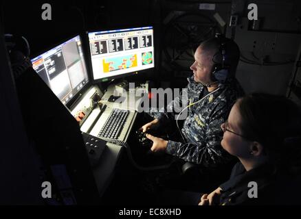 US Navy Matrosen betreiben die neu eingesetzten Gesetze, Laser-Waffe-System an Bord der Austin-Klasse amphibischen Dock Transportschiff USS Ponce 16. November 2014 in den Persischen Golf. 30 Kilowatt Laser-Waffensystem wurde an Bord der USS Ponce diesen Sommer als Teil eines $ 40 Millionen-Programm installiert und hat von der Marine am 10. Dezember 2014 betriebsbereit erklärt worden. Stockfoto