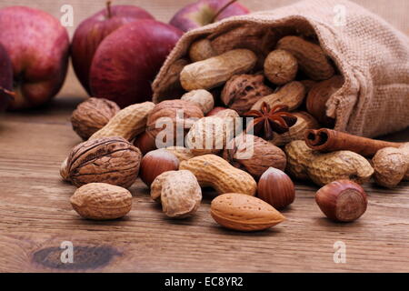 Muttern in Jute-Sack-Zimt-sticks, Sternanis und rote Äpfel Stockfoto