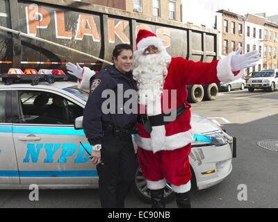 Santa Jingle Bell Parade in Greenpoint Abschnitt von Brooklyn, NY, 2013. Santa posiert für Fotos mit weiblich, NYPD Offizier. Stockfoto