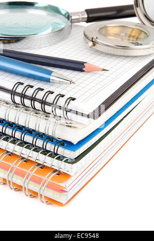 Feder und Bleistift auf Haufen Notebook isoliert auf weißem Hintergrund Stockfoto
