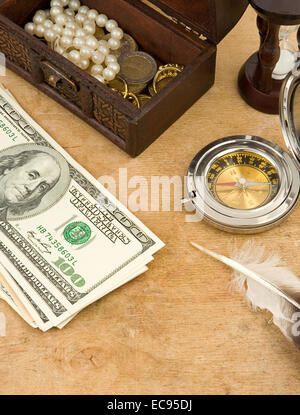 Dollar, Kompass und Sanduhr auf Holz Stockfoto