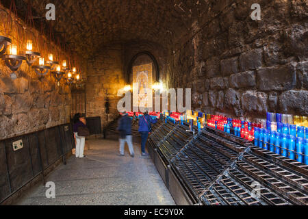 Gebet-Kerzen in Stein Korridor am Ausgang des Klosters der Basilika von Santa Maria de Montserrat in Katalonien, Spanien. Stockfoto