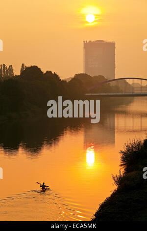 Ein Kanufahrer auf dem Rhein-Herne-Kanal bei Sonnenuntergang mit Gasometer Oberhausen Ruhr District, North Rhine-Westphalia, Deutschland Stockfoto