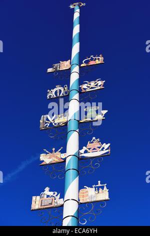 Maibaum mit Holzschilder von lokalen Geschäften, Miesbach, Bayern, Deutschland Stockfoto