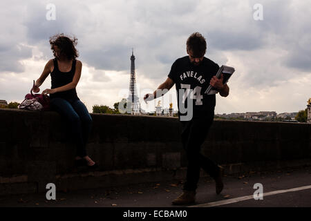 Frau sucht in ihrer Handtasche an einem windigen Tag in Paris auf dem Place De La Concorde. Stockfoto