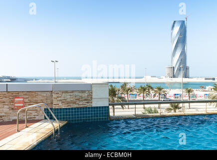 Manama, Bahrain - 21. November 2014: Schwimmbad und United Tower im Bau am Horizont in Manama, Hauptstadt Stockfoto