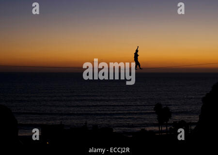 Mann geht eine Highline über dem Pazifischen Ozean in San Clemente, Kalifornien. Stockfoto