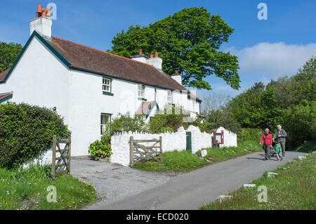 Menschen wandern vor Cotttages an Penrice Dorf Gower Wales Stockfoto