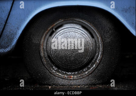 Detail mit einer schmutzigen Reifenpanne von einem alten blauen Pflege erschossen Stockfoto