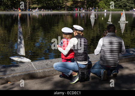 Familie mietet ein Spielzeugboot Wasserteich Segelboot Conservatory in New York Central park Stockfoto