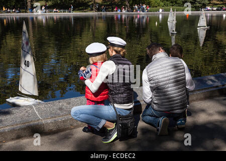 Familie mietet ein Spielzeugboot Wasserteich Segelboot Conservatory in New York Central park Stockfoto