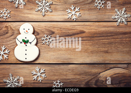 Weihnachten Hintergrund mit Lebkuchen in Form der Schneemann auf Holztisch. Kopieren Sie Raum. Ansicht von oben Stockfoto