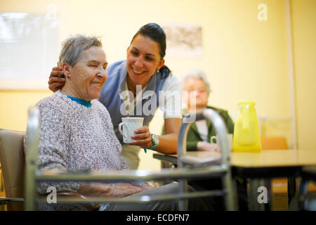 Frau, 79 Jahren in einem Pflegeheim, beim Frühstück, unterstützt durch eine geriatrische Krankenschwester, Stockfoto