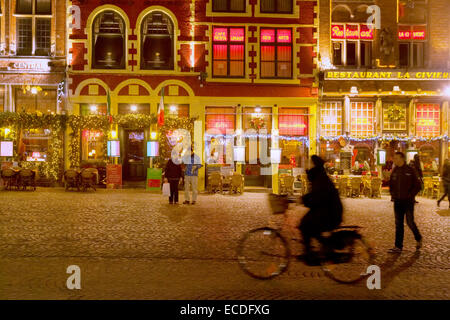 Ein Radfahrer Radsport vor eingerichteten Cafés zu Weihnachten, der Marktplatz (Markt), Innenstadt von Brügge, Belgien-Europa Stockfoto