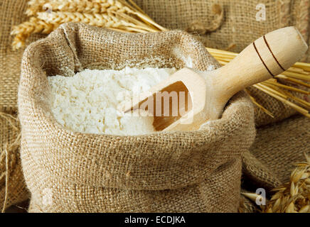 In Jute-Tasche und Holzlöffel Mehl Stockfoto