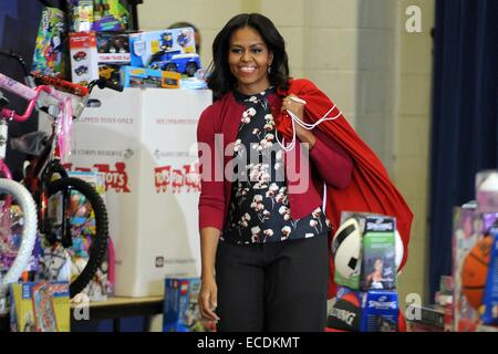 US-Präsidentengattin Michelle Obama kommt mit Taschen voller Spielzeug während des Marine Corps Spielzeug für Kleinkinder-Kampagne am Joint Base Anacostia-Bolling 10. Dezember 2014 in Washington, DC. Stockfoto