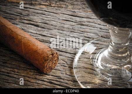 Zigarre mit Glas Rotwein auf hölzernen Hintergrund Stockfoto