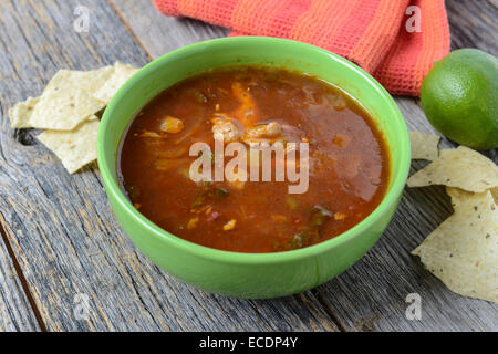Tortilla Suppe mit Pommes Frites und frische Limette auf rustikalen Holz-Hintergrund Stockfoto