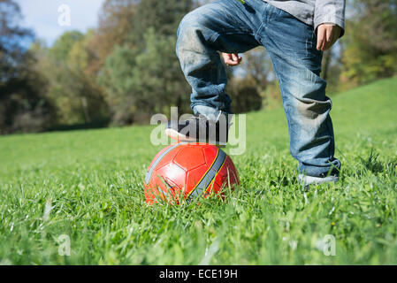 Kleiner Junge auf roten Fußball Wiese treten hautnah Stockfoto