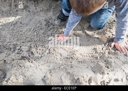 Kleiner Junge spielt im Sandkasten Spielplatz Stockfoto