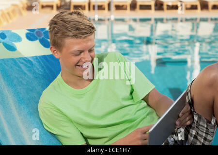 Junge männliche Schwimmbad mit Tablet-PC Stockfoto