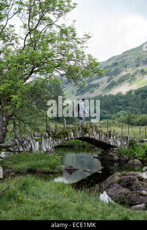 Wanderer überquert Slater in kleinen Langdale im englischen Lake District. Slater-Brücke ist eine alte Lastesel. Stockfoto