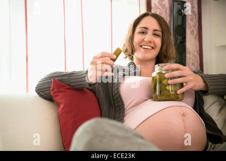 Schwangere Frau hungrig Essen Essiggurken Stockfoto