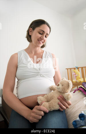 Schwangere Frau mit Spielzeug Teddybär Stockfoto