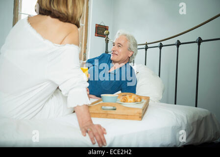 Paar beim Frühstück im Bett, Lächeln Stockfoto