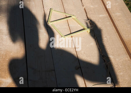Schatten der Person auf Holz neben Falten Herrscher Stockfoto