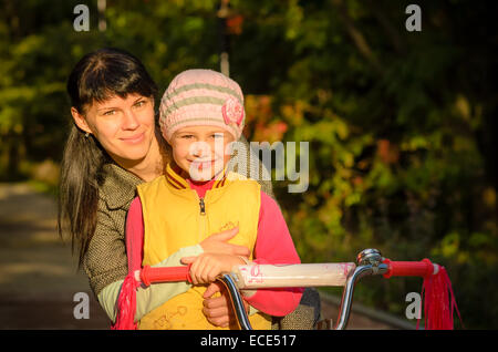 Mutter und Tochter sitzen auf dem Fahrrad, Nahaufnahme Foto Stockfoto