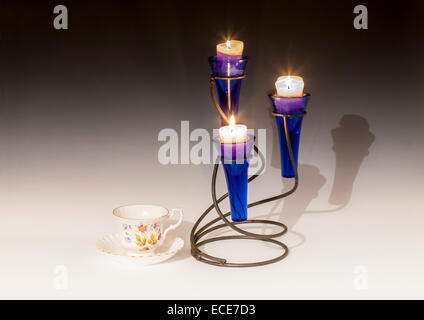 Kerzen mit Bone China Tasse und Untertasse. Stockfoto